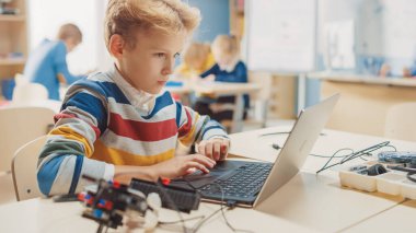 Genç Öğrenci, Robot Mühendisliği Sınıfı için Dizüstü bilgisayar kullanıyor. Teknoloji ile çalışan yetenekli parlak çocukların olduğu ilköğretim okulu bilim sınıfı.