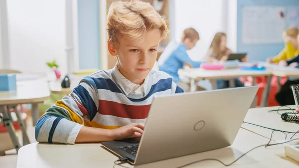 Smart Schoolboy používá notebook k programovému softwaru pro třídu robotického inženýrství. Základní škola věda učebna s nadanými brilantní děti pracující s technologií — Stock fotografie