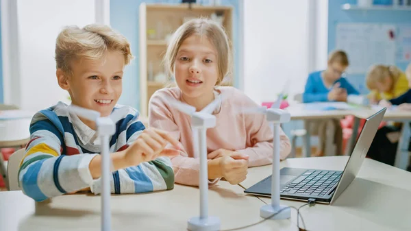 Colegiala y colegial trabajan con prototipo de turbina eólica, aprendiendo sobre el medio ambiente y las energías renovables. Aula de Ciencias de la Escuela Primaria con Niños que Trabajan en Tecnología. Educación STEM — Foto de Stock