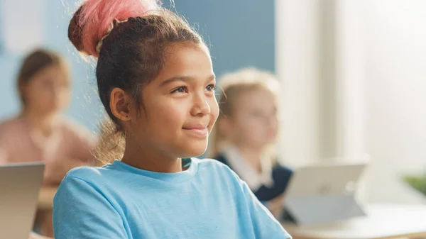 Porträt eines süßen kleinen Mädchens mit braunen Haaren, das charmant lächelt und lacht, während es den Lehrer ansieht. — Stockfoto