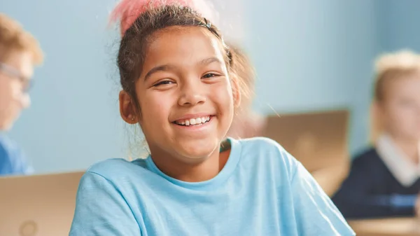Porträt eines süßen kleinen Mädchens mit braunen Haaren, das charmant lächelt und lacht, während es in die Kamera blickt. — Stockfoto