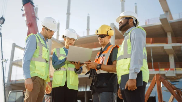 Diverse Team of Specialists Use Laptop Computer on Construction Site. Real Estate Building Project with Machinery: Civil Engineer, Investor, Businesswoman and Builder Discussing Blueprint Plan — Stock Photo, Image