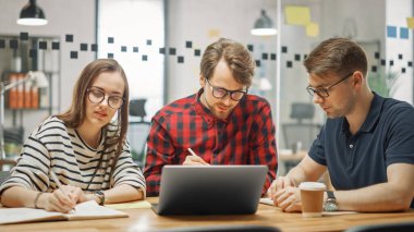 Genç Kadın ve İki Erkek İş Arkadaşı Arkadaşça Buluşup Yeni İş Fikirlerini Tartışıyor. Daire Ofisi Yaratıcı Ajansı 'nda Birlikte Çalışmanın Kolay Atmosferi. Laptop ve Tablet 'te Not Alırlar.