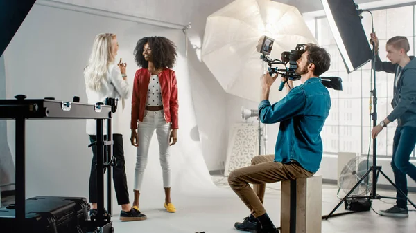 Cameraman riprese make-up artista applica il trucco ad un bellissimo modello nero. Mettono in posa per un videoclip. Elegante rivista di moda. Scatto fotografico fatto con attrezzature Pro in uno studio — Foto Stock