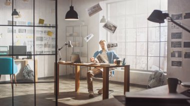 Hüsrana uğramış ve yorgun genç yaratıcı tasarımcı masasındaki dizüstü bilgisayarında, Çarşafları ve 