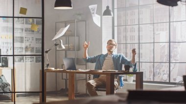 Hüsrana uğramış ve yorgun genç yaratıcı tasarımcı masasındaki dizüstü bilgisayarında, Çarşafları ve 