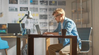 Yaratıcı Geliştirici Stüdyosunda Dizüstü bilgisayarda çalışıyor. Uygulamalar, Oyunlar ve Video Düzenleme Tasarımı. Arka plan Modern Sunny Çatı Ofisi 'nde Storyboard Projesi ve Duvarı Kaplayan Kavramlarla