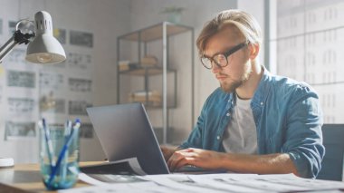 Yaratıcı Geliştirici Stüdyosunda Dizüstü bilgisayarda çalışıyor. Uygulamalar, Oyunlar ve Video Düzenleme Tasarımı. Arka plan Modern Sunny Çatı Ofisi 'nde Storyboard Projesi ve Duvarı Kaplayan Kavramlarla