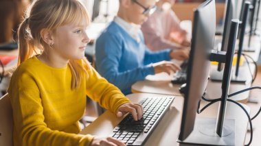 İlkokul Bilgisayar Bilimi Sınıfı: Şirin Küçük Kız Kişisel Bilgisayar Kullanıyor, Yazılım Kodlaması için Programlama Dili Öğreniyor. Modern eğitim alan okul çocukları. Yan Görünüm Portresi