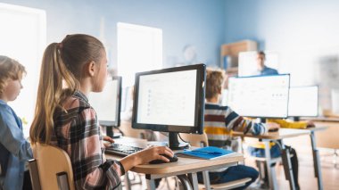 İlkokul Bilgisayar Bilimi Sınıfı: Şirin Küçük Kız Kişisel Bilgisayar Kullanıyor, Yazılım Kodlaması için Programlama Dili Öğreniyor. Öğrenciler Modern Eğitime Gidiyor.