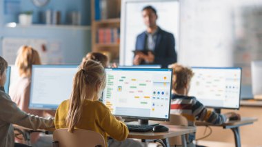 İlköğretim Okulu Bilgisayar Bilimi Sınıfı: Öğretmen Dijital Tablet Kullanıyor, Çeşitli Akıllı Çocuklar Grubuna Ders Açıklıyor. Modern eğitim alan çocuklar, İnternet Güvenliğini Öğrenin, Yazılım Programı