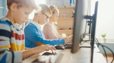 İlköğretim Okulu Sınıfı: Gözlüklü Akıllı Bir Çocuğun Portresi Kişisel Bilgisayarı Kullanıyor, İnterneti Güvenli Kullanmayı Öğreniyor, Yazılım Kodlaması İçin Programlama Dili. Çocuklar için Modern Eğitim