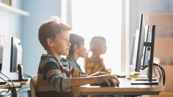 Δημοτικό Σχολείο Computer Science Classroom: Smart Little Schoolboy Λειτουργεί σε προσωπικούς υπολογιστές, εκμάθηση γλώσσας προγραμματισμού για Κωδικοποίηση Λογισμικού. Μαθητές που αποκτούν σύγχρονη εκπαίδευση — Φωτογραφία Αρχείου