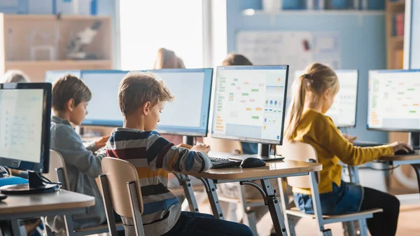 小学计算机科学课室：聪明的小学生在个人电脑上工作，学习编程语言进行软件编码。接受现代教育的学童 — 图库照片