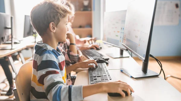 Scuola elementare Aula: Smart Boy utilizza Personal Computer, Imparare a utilizzare Internet in modo sicuro, Linguaggio di programmazione per la codifica del software. Studenti che ricevono un'educazione moderna. Ritratto girato — Foto Stock