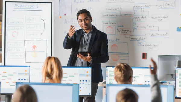 Scuola elementare Computer Science Class: Insegnante utilizza tavoletta digitale, Spiega Lezione a Diverso gruppo di bambini intelligenti. I bambini ricevono un'educazione moderna, imparano la sicurezza di Internet, programmazione software — Foto Stock