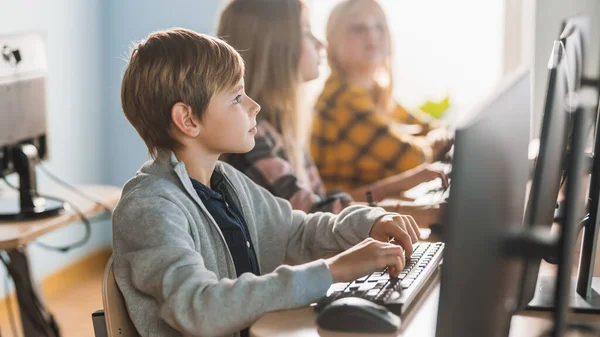 Elementary School Computer Science Classroom: Smart Little Schoolboy Trabalha em Computadores Pessoais, Aprendendo Linguagem de Programação para Codificação de Software. Crianças em idade escolar obtendo educação moderna — Fotografia de Stock