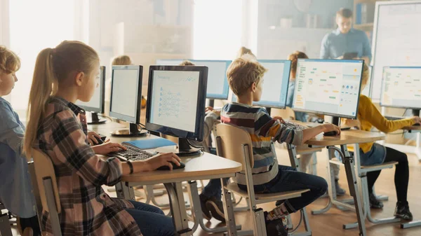 Grundskola datavetenskap Klassrum: Smart små skolbarn Arbeta med persondatorer, lära sig programmering språk för programvarukodning. Skolbarn får modern utbildning — Stockfoto