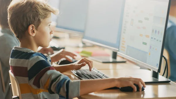Peruskoulun tietojenkäsittelytieteen luokkahuone: Smart Little Schoolboy Works on Personal Computers, Oppiminen ohjelmointikieli ohjelmisto koodaus. Koululaiset Nykyaikainen koulutus — kuvapankkivalokuva