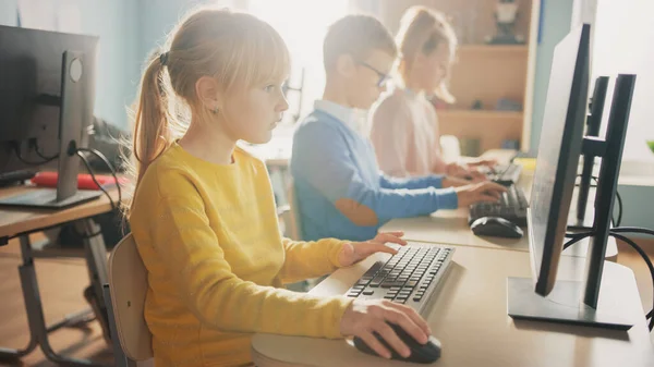 Escola Primária de Ciência da Computação Sala de aula: Menina bonito usa computador pessoal, aprendizagem de linguagem de programação para codificação de software. Crianças em idade escolar obtendo educação moderna . — Fotografia de Stock