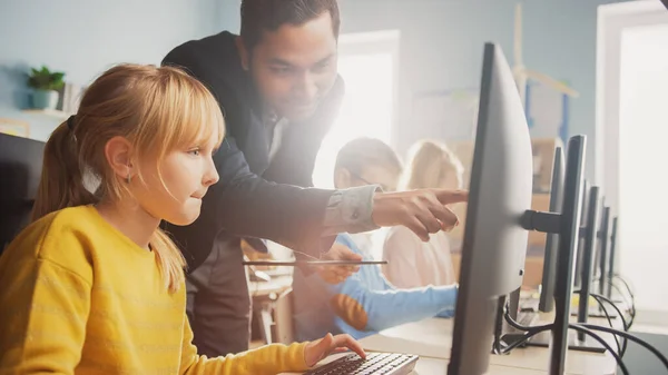 Sala de aula de ciências da escola primária: professor explica a uma pequena estudante inteligente como usar o computador pessoal, para aprender a linguagem de programação necessária para codificação de software. Educação moderna em progresso — Fotografia de Stock