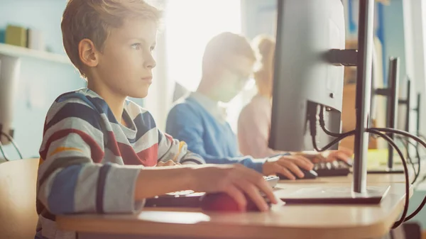 Escuela Primaria de Ciencias de la Computación Aula: Smart Little Boy utiliza la computadora personal, aprendiendo cómo utilizar Internet de forma segura, el lenguaje de programación para la codificación de software. Educación moderna. Vista de retrato —  Fotos de Stock