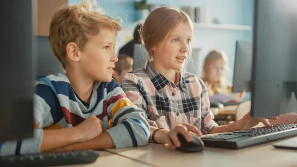 Класс компьютерных наук начальной школы: Портрет умной девочки и мальчика, разговаривающих при использовании персонального компьютера, обучение информатике, безопасность Интернета, язык программирования для кодирования программного обеспечения — стоковое фото