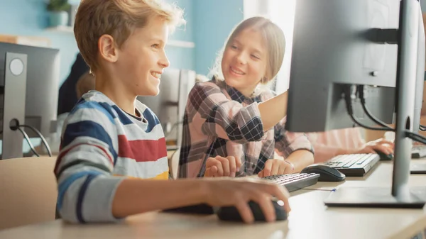 Класс компьютерных наук начальной школы: Портрет умной девочки и мальчика, разговаривающих при использовании персонального компьютера, обучение информатике, безопасность Интернета, язык программирования для кодирования программного обеспечения — стоковое фото