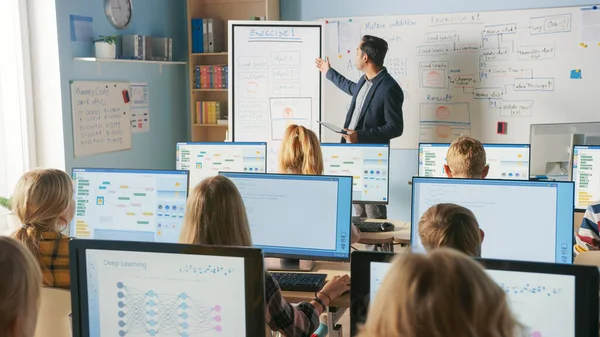 Grundskoleklass: Lärare använder interaktiv digital whiteboard, förklarar lektion för olika grupper av smarta barn. Barn som får modern utbildning, lära sig datavetenskap, programvara Programmering — Stockfoto