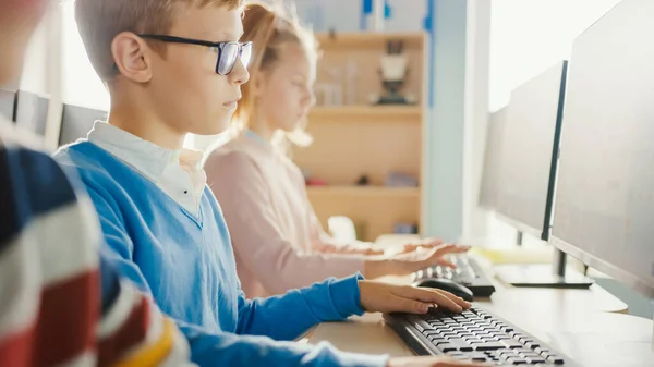 Grundskola Klassrum: Porträtt av en smart pojke med glasögon använder persondator, lära sig att använda Internet säkert, programmering språk för programvarukodning. Modern utbildning för barn — Stockfoto