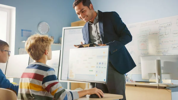 Grundskola datavetenskap Klassrum: Lärare använder Tablet Computer, förklarar Lesson till olika grupp av smarta barn. Dataklass för barn — Stockfoto