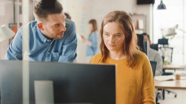 Masaüstü Bilgisayarında Kadın Uzman Çalışıyor, Proje Yöneticisi Yanında Duruyor ve Müşteri Tecrübe Yönetimi İçin İş Akımının İyimserleştirilmesi Konusunda Tavsiye Veriyor. Çeşitli Profesyoneller Takımıyla Modern Ofis