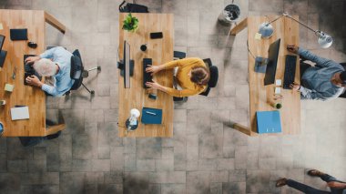 Ofisteki En İyi Görünüm Çekimi: Masalarında Masaüstü Bilgisayarları Üzerinde Çalışan Çeşitli Girişim Çalışanları Grubu. Profesyonellerin işini yaptığı modern ve şık bir ofis.