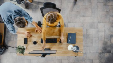 Üst Görünüm: Kadın Ofis İşçisi Masaüstü Bilgisayarı Kullanıyor, Proje Yöneticisi Yanında Duruyor ve Müşteri Tecrübesi Yönetimi İçin Çalışma Akımının İyimserleştirilmesi Konusunda Tavsiye Veriyor.