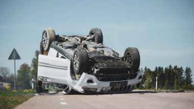 Korkunç Trafik Kazası, Yuvarlanan Sigara İçme ve Yanan Araç Çarpışmadan Sonra Yolun Ortasında Çatısında Yatıyor. Ağır Hasarlı Modern SUV Arabalı Gündüz Çarpışması.