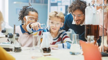 İlköğretim Okulu Bilim Sınıfı Küçük Çocuk Kimyasalları Beakers 'a Karıştırıyor. Coşkulu Öğretmen Kimya 'yı Çeşitli Çocuklar Grubuna Açıklıyor. Çocuklar Faiziyle Öğrenin