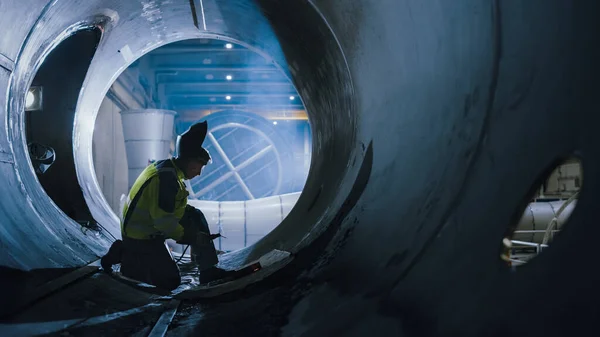 Soldador profesional de la industria pesada que trabaja dentro de la tubería, usa casco y comienza la soldadura. Construcción del Gasoducto de Petróleo, Gas Natural y Combustibles. Fábrica de fabricación industrial — Foto de Stock