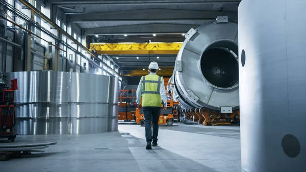 Za Shot of Heavy Industry Engineers Walking Through Manufacturing Factory. W tle Profesjonaliści zajmujący się budową produktów do transportu ropy naftowej, gazu i paliwa — Zdjęcie stockowe