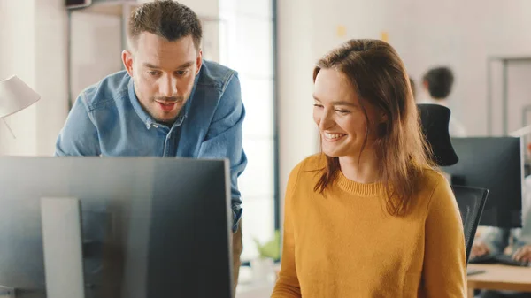 Especialista femenina trabaja en la computadora de escritorio, Project Manager se queda al lado y da consejos sobre la optimización del flujo de trabajo para la gestión de la experiencia del cliente. Oficina moderna con equipo diverso de profesionales — Foto de Stock