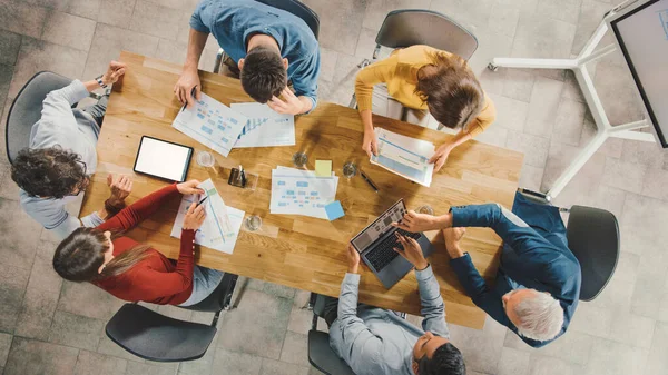 Startup Meeting Room: Team of Entrepreneurs sitting at Conference Table Have Discussions, Solve Problems, Use Digital Tablet, Laptop, Share Documents with Statistics, Charts. 톱 뷰 샷 — 스톡 사진