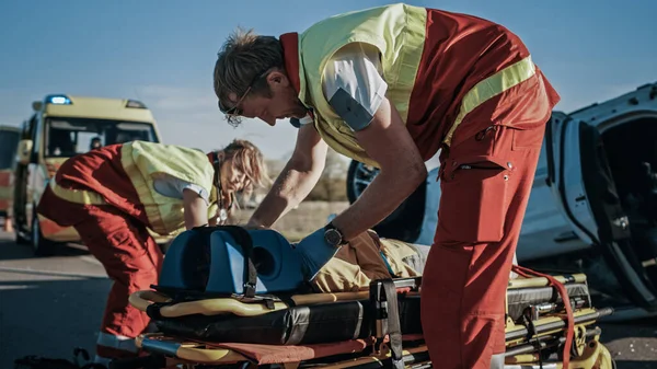 På bilolyckan Trafikolycka Scen: Paramedicin och brandmän Rädda skadade Fångad i fordonet. Befriad person som använder bårar, ge första hjälpen och transportera dem till sjukhus — Stockfoto