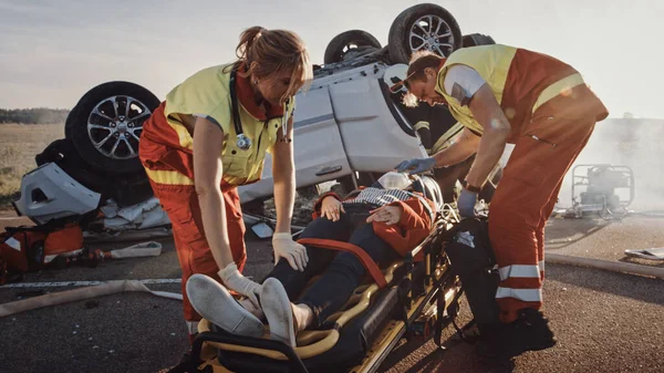 2008 년 7 월 1 일에 확인 함 . On the Car Crash Traffic Accident Scene: Paramenters Saving Life of a Female victim who are lying on Stretchers.. 그들은 산소 마스크를 착용하고 응급 치료를 한다. 배경에 있는 롤러 버스 차량 — 스톡 사진