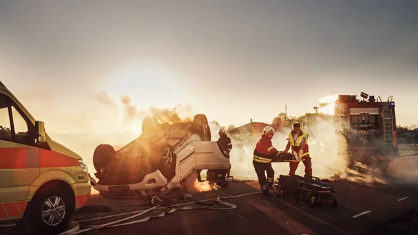 På bilolyckan Trafikolycka Scen: Paramedicin och brandmän Rädda skadade Fångad i fordonet. Befriad person som använder bårar, ge första hjälpen och transportera dem till sjukhus — Stockfoto