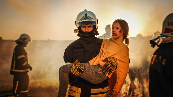 Bombeiro corajoso leva menina ferida para a segurança. No fundo acidente de trânsito acidente de carro com paramédicos corajosos e bombeiros salvar vidas, Fogo de combate — Fotografia de Stock