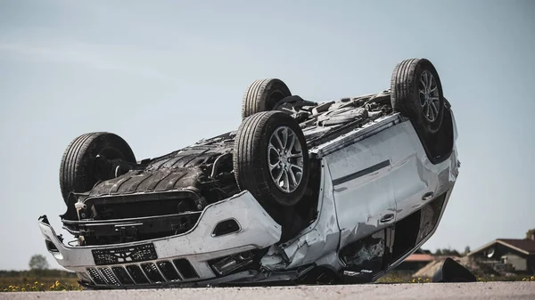 Hemsk trafikolycka, vältning rökning och brinnande fordon ligger på taket i mitten av vägen efter kollision. Dagtid krasch scen med allvarligt skadade moderna SUV bil. — Stockfoto