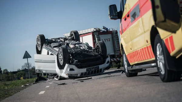 Räddningsteamet av brandmän anländer på bilkraschtrafikplatsen på deras brandbil. I bakgrundsgruppen av brandmän och brandbilar. — Stockfoto