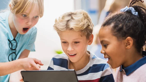 小学校コンピュータサイエンスクラス:二人の女の子と男の子拡張現実ソフトウェアとデジタルタブレットコンピュータを使用します。,彼らは興奮します。STEM 、遊び、学びの子供たち — ストック写真