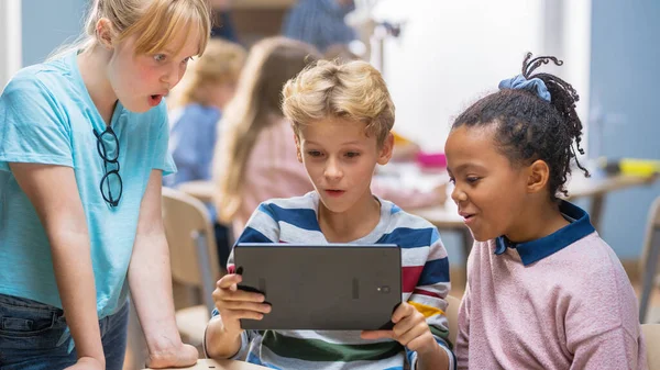 Základní škola počítačové vědy třída: Dvě dívky a chlapec používat digitální tablet počítač s rozšířenou realitou software, oni re excited, Plný divů, zvědavost. Děti v STEM, hraní, učení — Stock fotografie