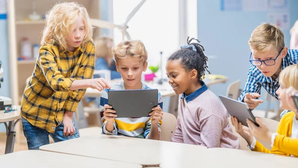 Clase de Ciencias de la Computación Escolar: Los escolares utilizan Tablet Computadoras Digitales y Smartphones con Software de Realidad Aumentada, se vuelven emocionados, llenos de maravillas. Niños en STEM, jugando y aprendiendo —  Fotos de Stock