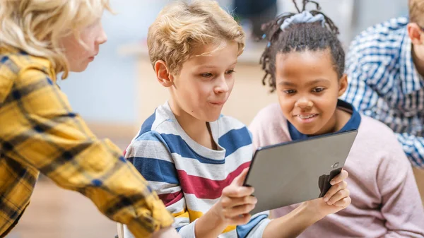 Clase de Ciencias de la Computación de la Escuela Primaria: Los niños usan Tablet Computadoras Digitales y Smartphones con Software de Realidad Aumentada, se vuelven emocionados, llenos de maravillas. Niños en STEM, jugando y aprendiendo —  Fotos de Stock